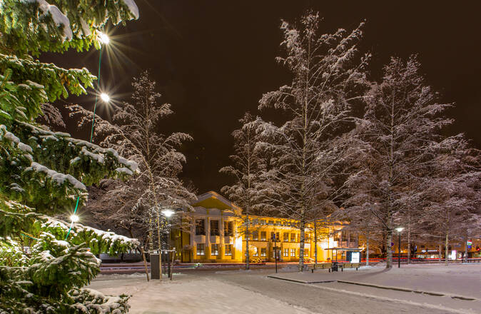 Kaupungintalo, lumisia puita ja joulukuusi.