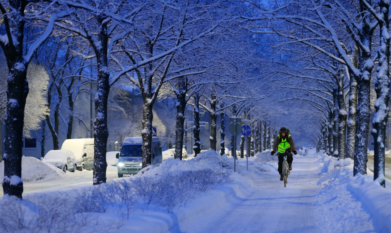 Pyöräilijä talvisella kadulla.