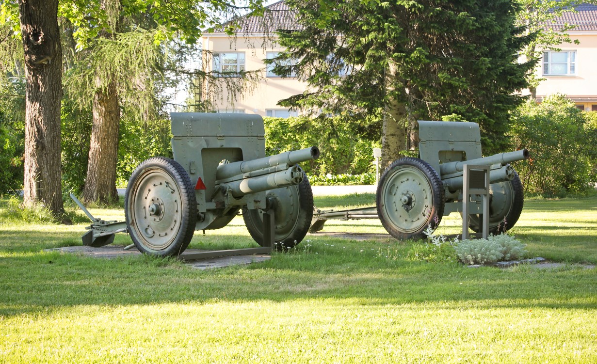 Kaksi sodanaikaista tykkiä nurmikolla.