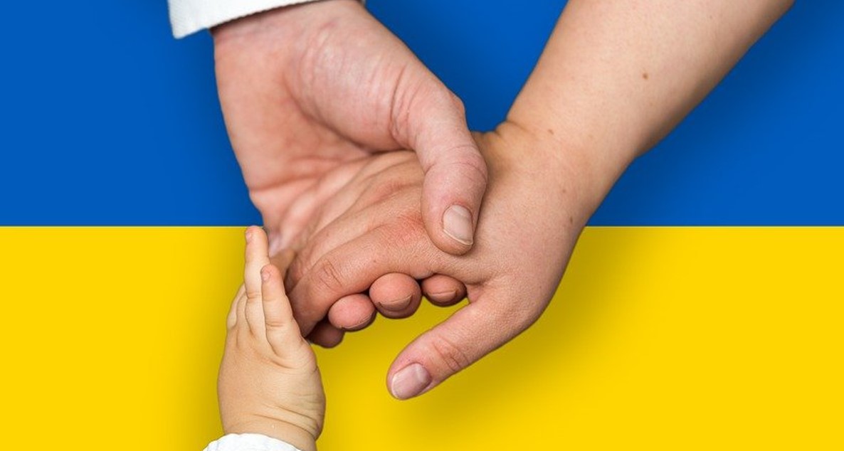 Ukrainan lippu, jonka edessä käsiä.