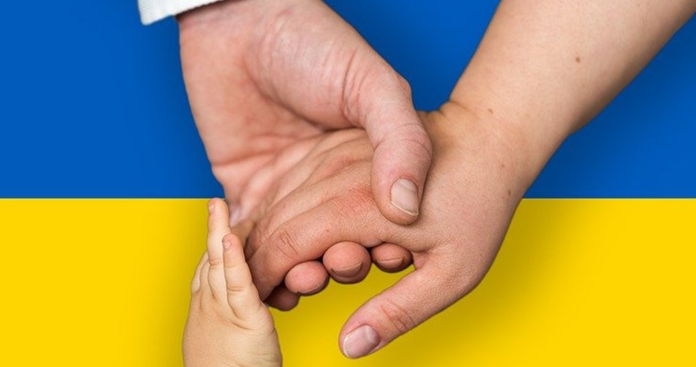 Ukrainan lippu, jonka edessä kolme kättä.