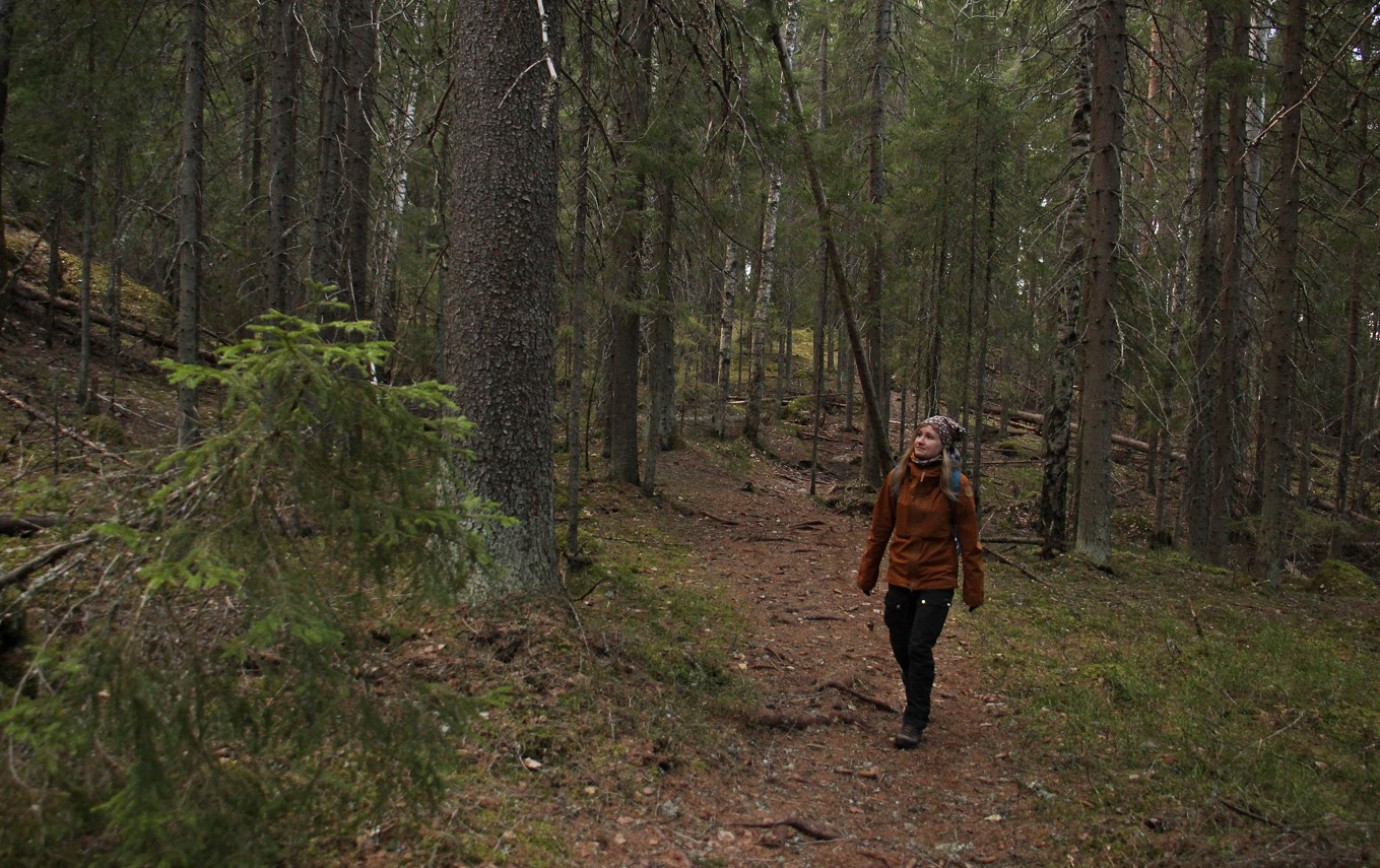 Nainen kävelee metsässä.