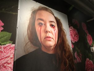 Taidenäyttelyn teos, jossa nainen itkee verta.