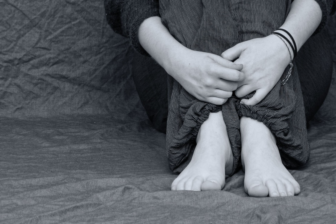 Mustavalkoinen kuva, jossa henkilön jalat ja kädet.
