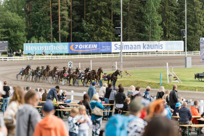 Ravureita juoksemassa raviradalla, etualalla yleisöä.