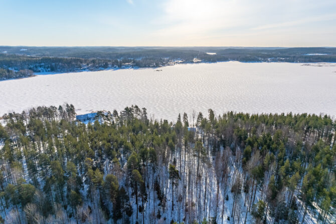 Ilmakuva järvimaisemasta, etualalla metsäistä maisemaa.