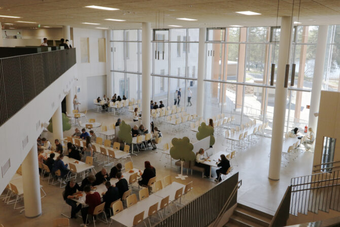 Ruokailijoita koulun ruokalassa.