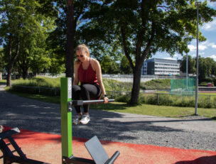 Nainen ulkokuntosalilaitteella.