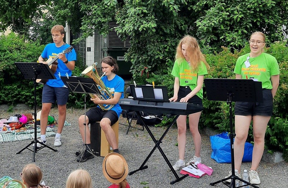 Kesätyöntekijöitä soittamassa ja laulamassa lapsille.