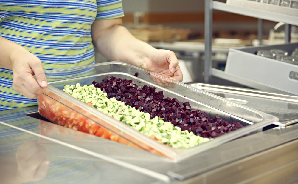 Keittiötyöntekijä salaattiastian kanssa.