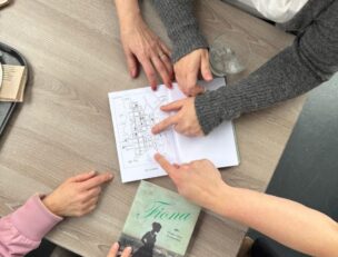 Ihmisten käsiä ja kirjoja.