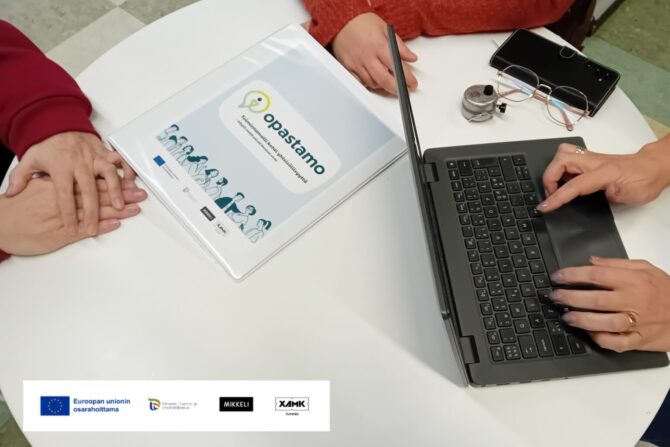 Ihmisten käsiä pöydän äärellä.