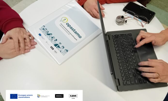 Ihmisten käsiä pöydän äärellä.