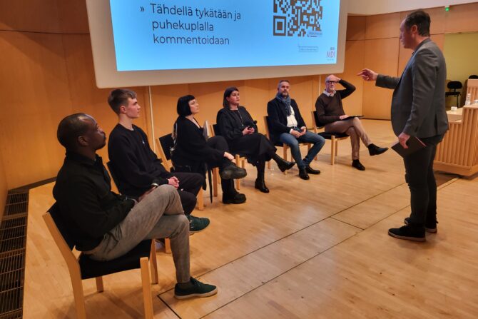 Keskustelijoita istumassa.