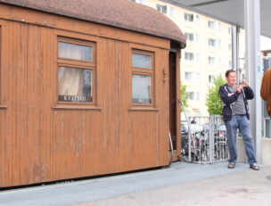 Salonkivaunun toinen pääty ja henkilö ottamassa valokuvaa.