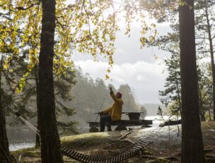 Kalastaja syksyisessä järvimaisemassa.