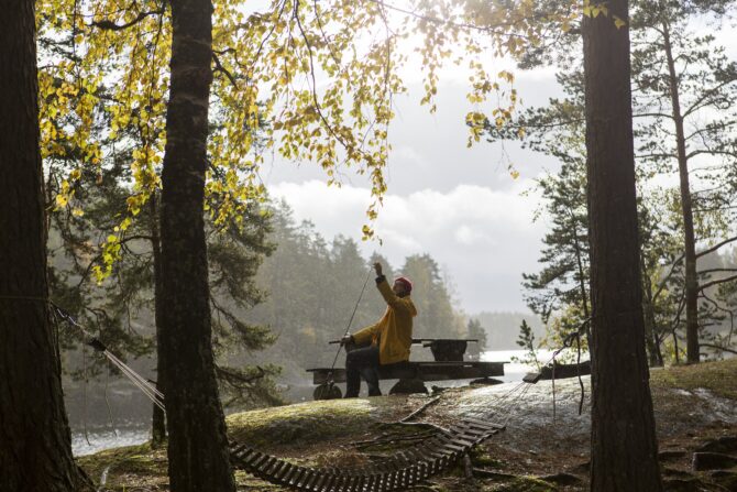 Kalastaja syksyisessä järvimaisemassa.