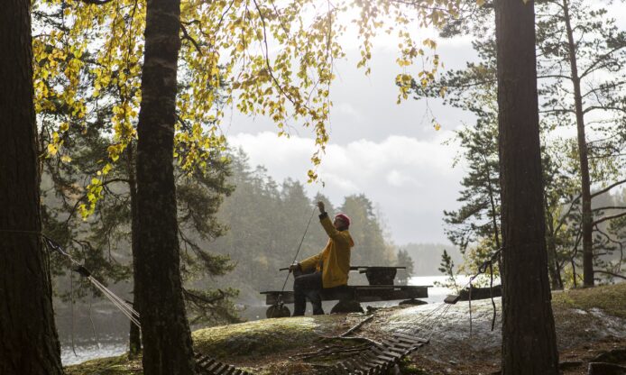 Kalastaja syksyisessä järvimaisemassa.