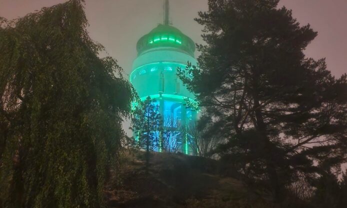 Naisvuoren torni vihreässä valaistuksessa illalla.
